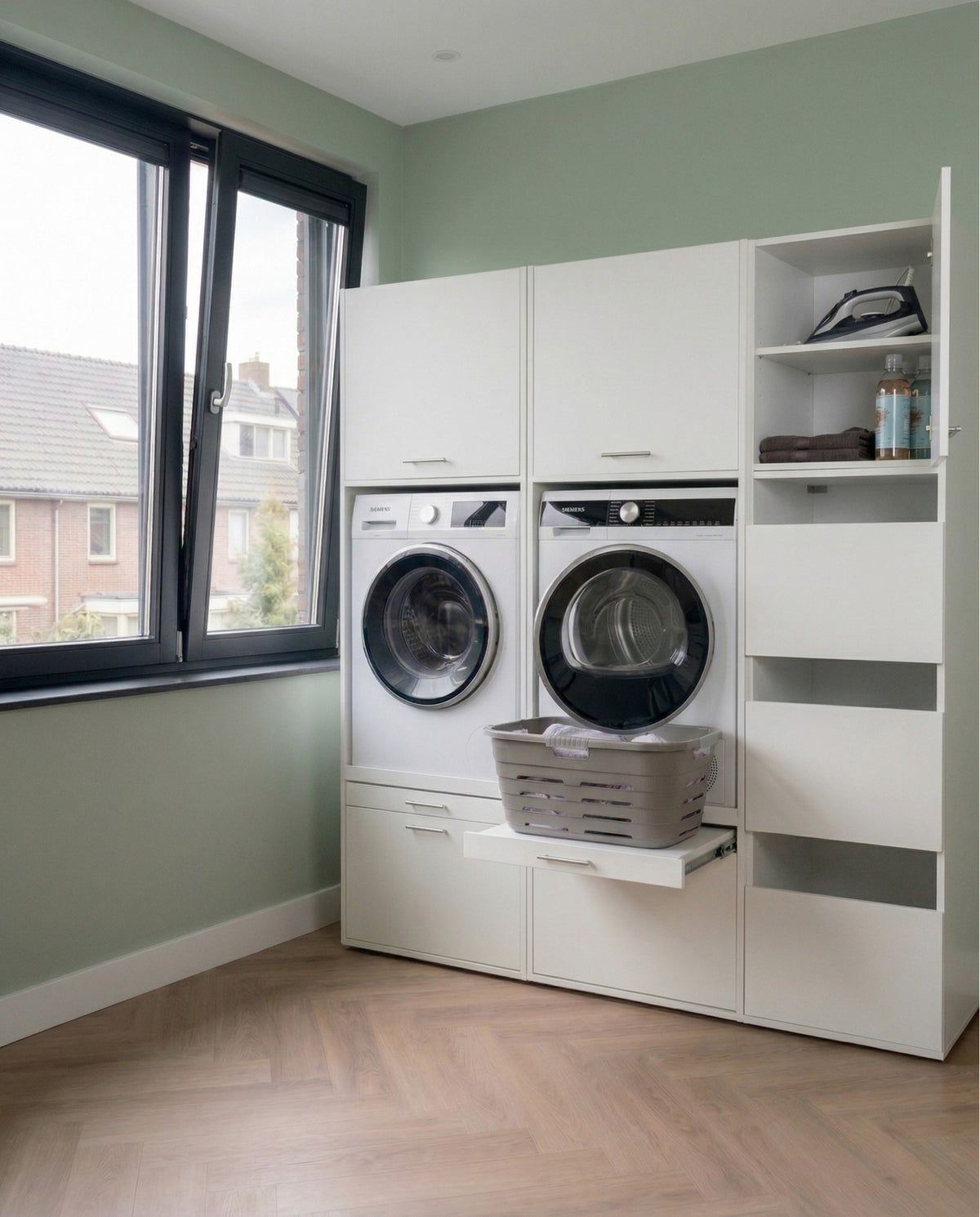 White front-loading washer and dryer set with tall storage cabinet and laundry basket on pull-out shelf in modern laundry.