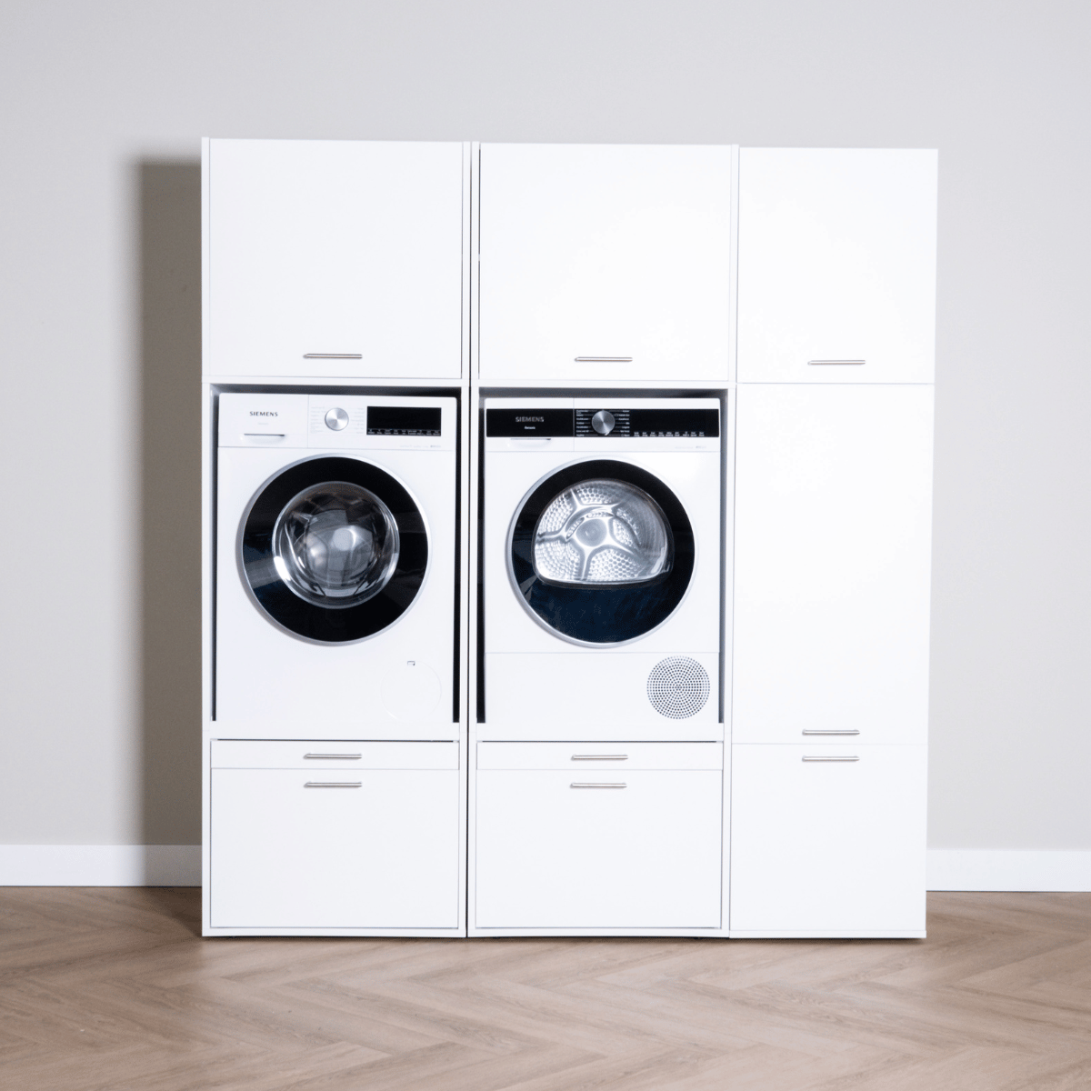 White high cabinet set with integrated front-load washer and dryer, sleek modern handles.